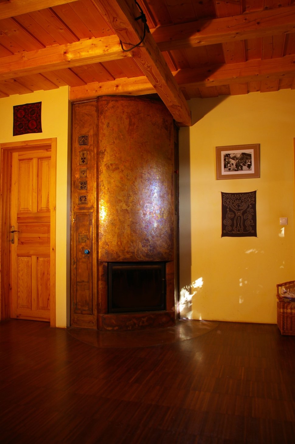 The copper stove in a wood-panelled room, lit by warm lamps.