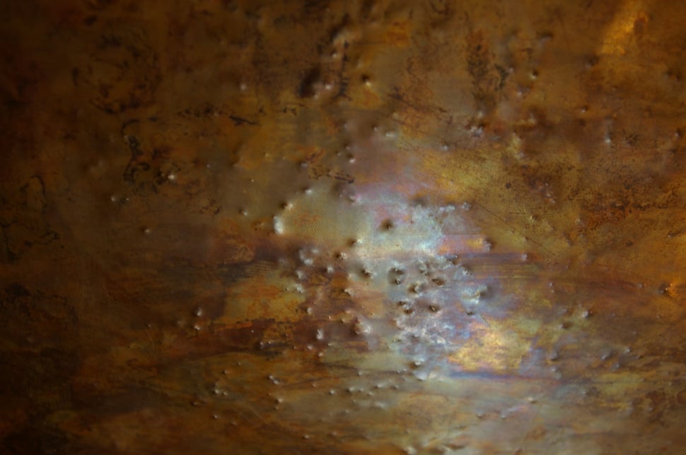 Close-up of the mottled, patinated copper surface.