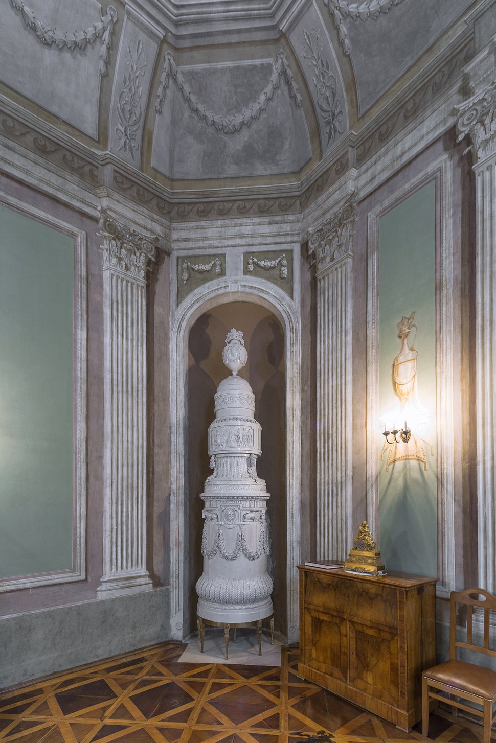 Another view of the white stove in the palace room, with chairs.