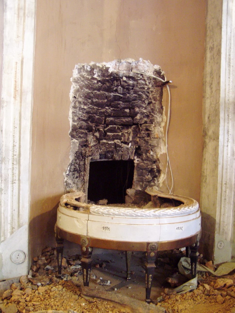 The old stove base with a firebox and exposed brick chimney.