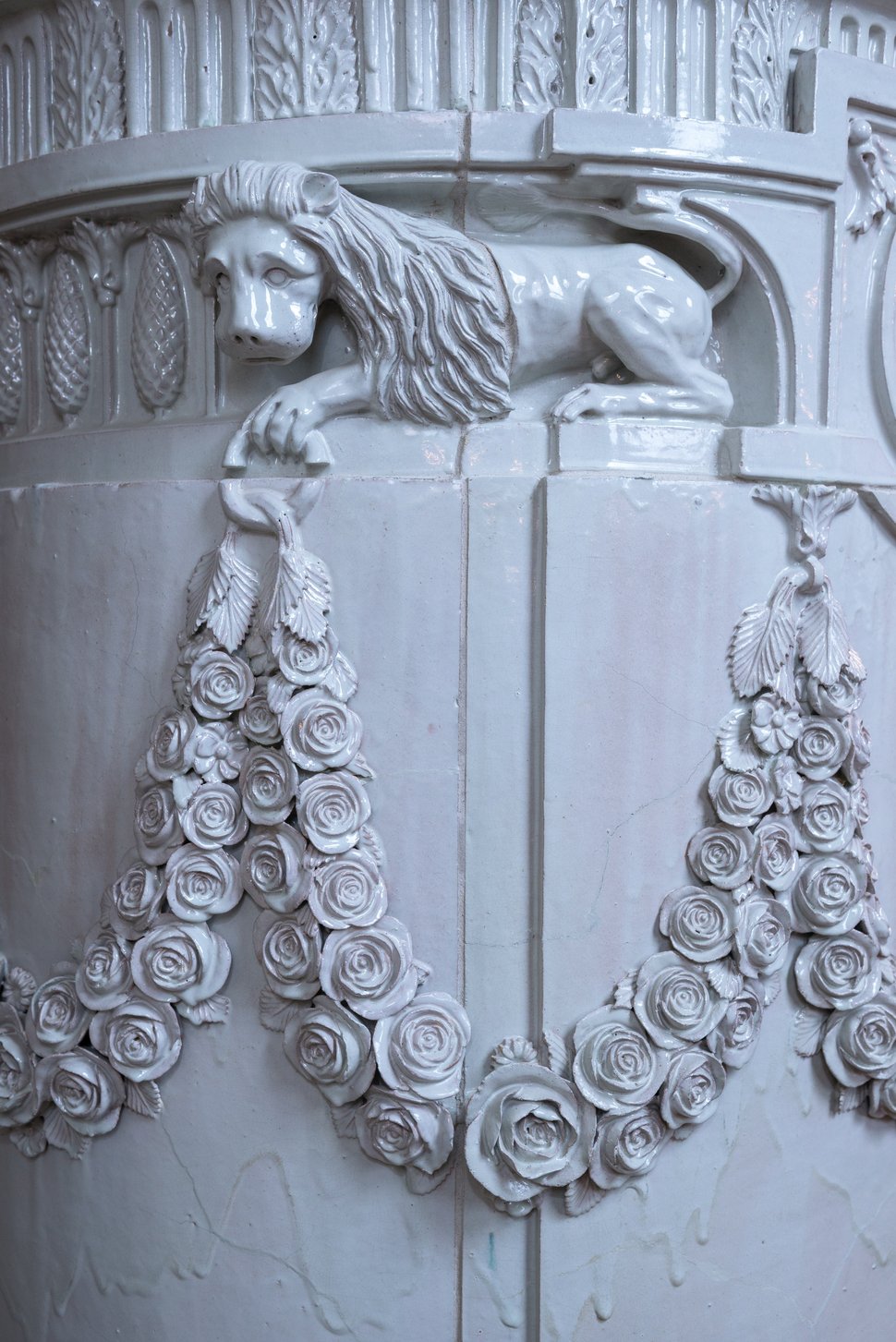 A white lion relief with a garland on the palace stove.