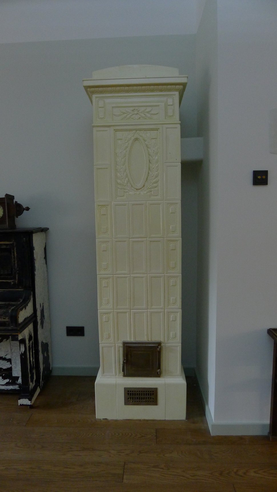 The long stove lying on its side on a white platform.