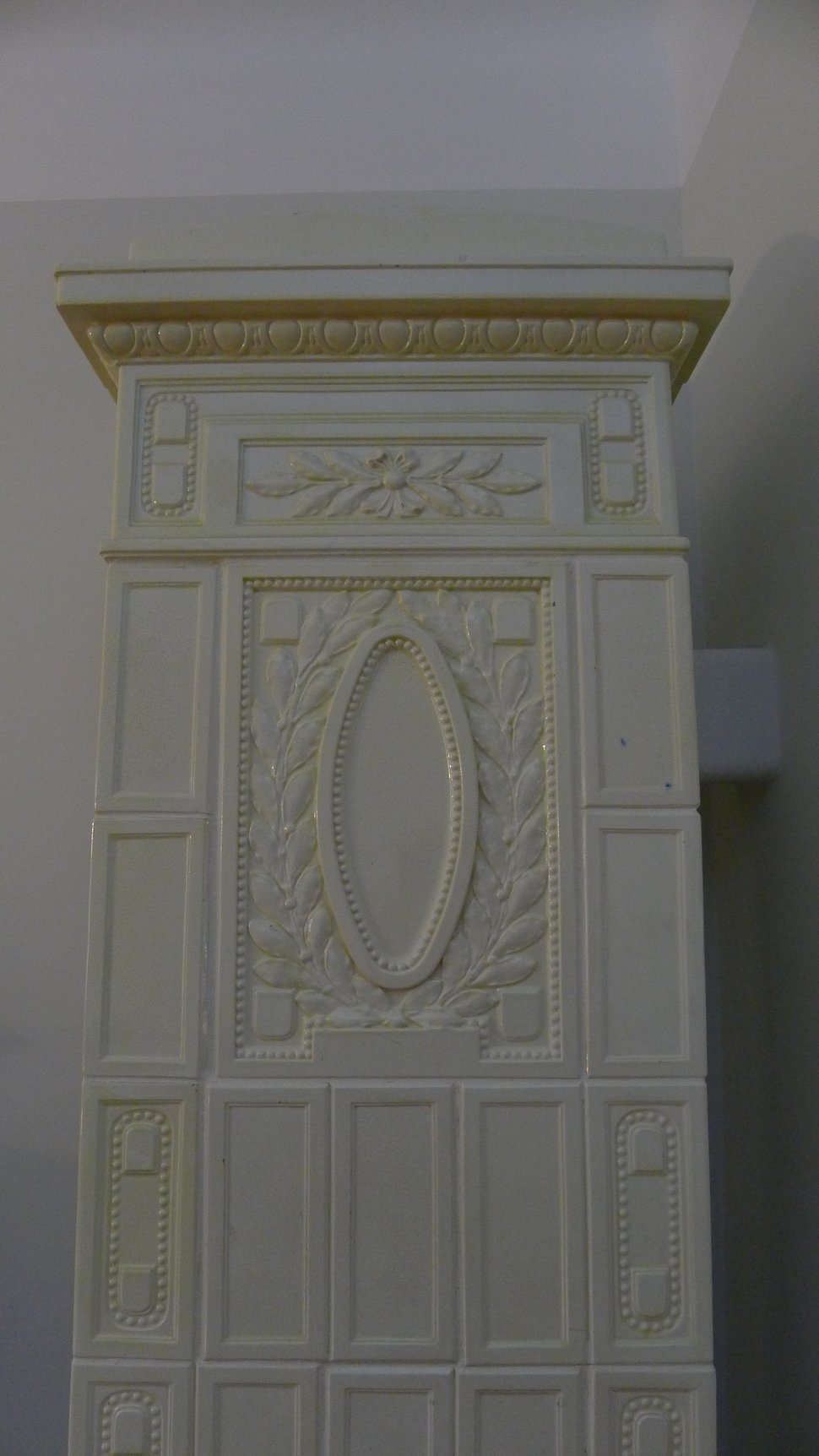Carved relief panels on the cream stove, with an oval motif.