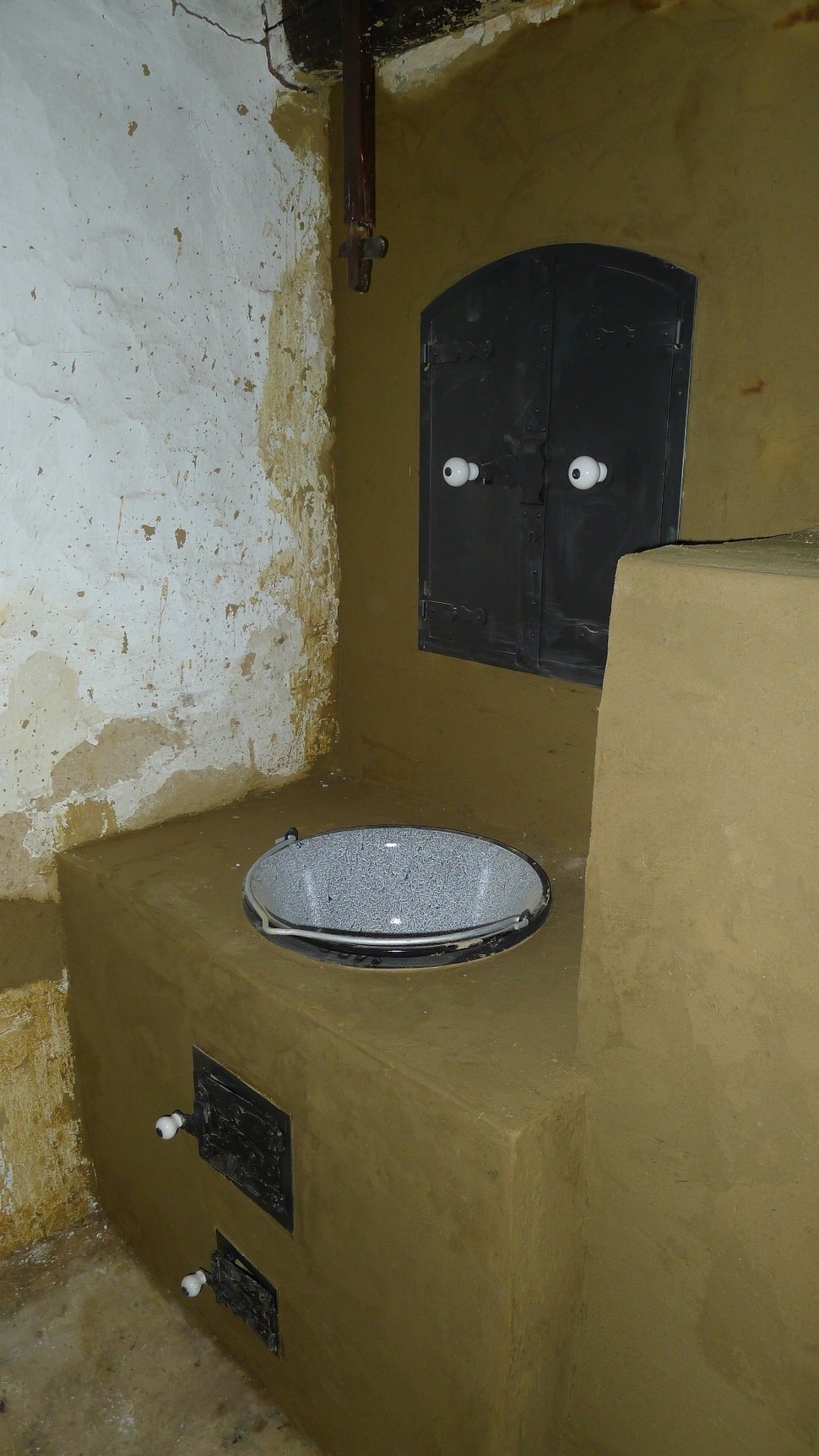 The beige stove with an open firebox and a white bowl on the ledge.