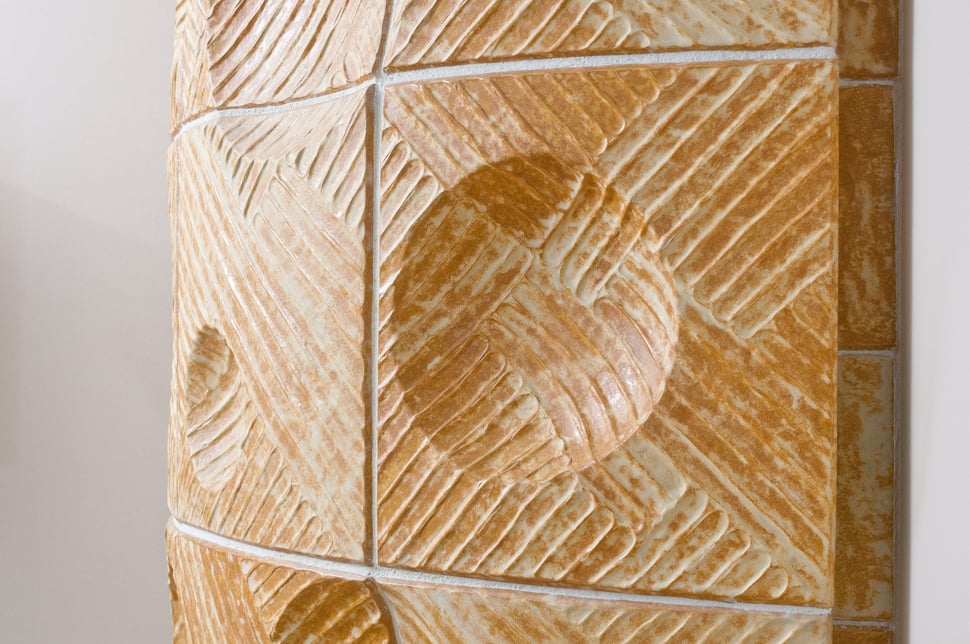 Close-up of carved tiles with a swirl pattern and incised lines.