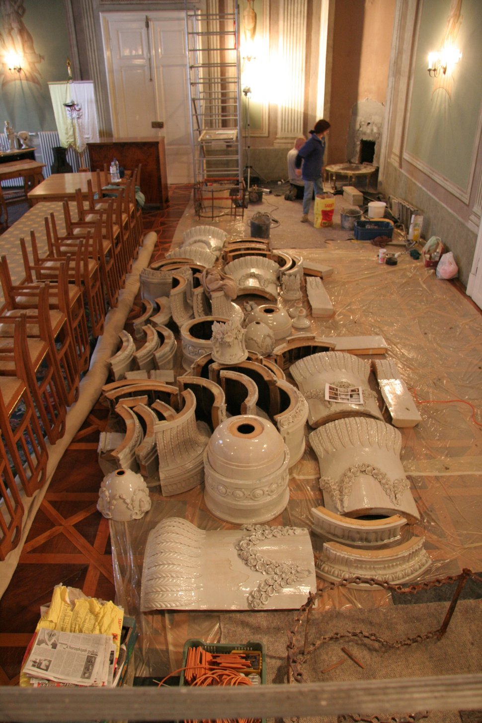 A workshop wall lined with restored white stove pieces.