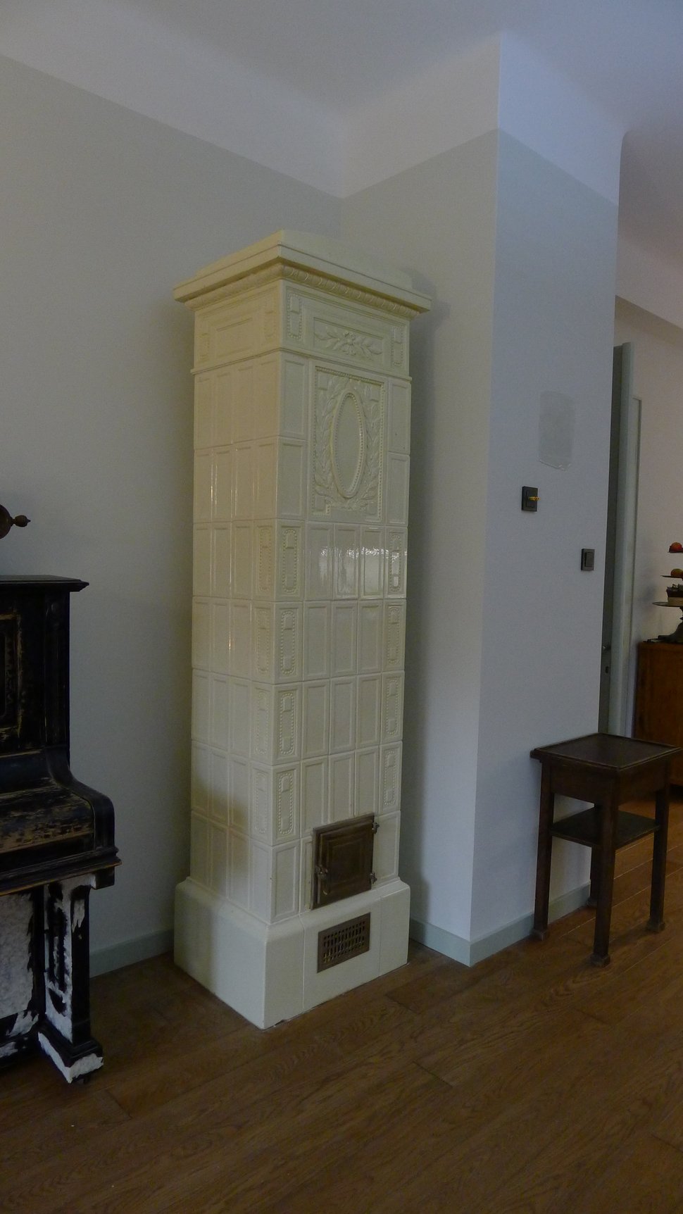 The stove on its side beneath a ceiling, in a room being finished.