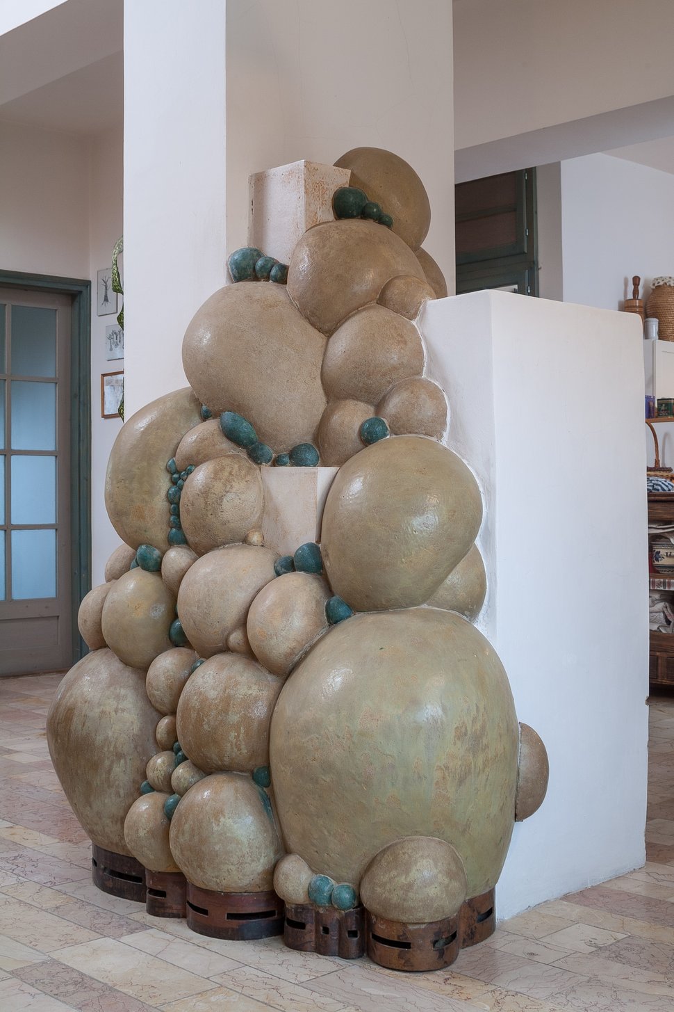A stack of large rounded ceramic forms beside a white wall.