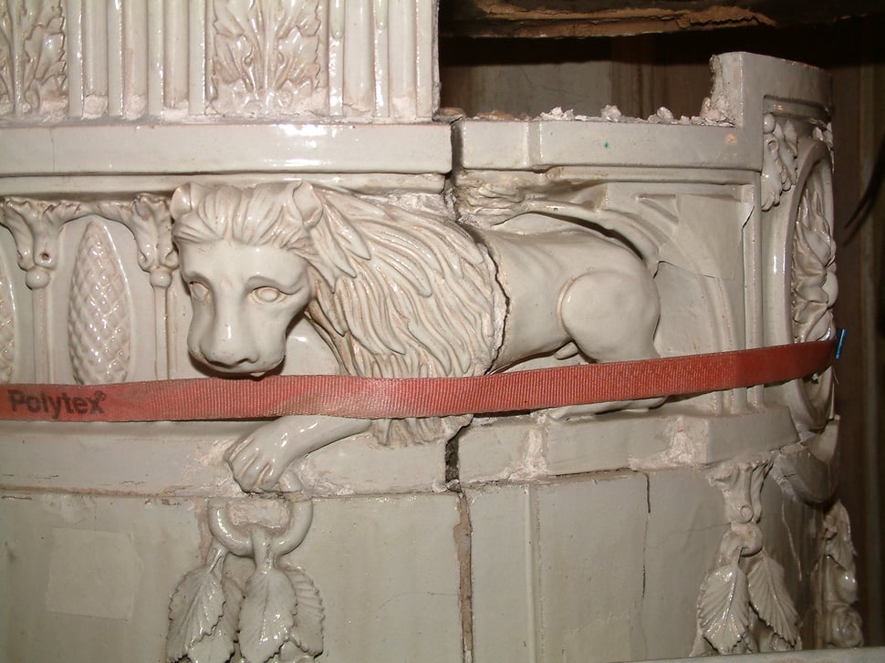 A white lion relief on the stove, crossed by a red strap.