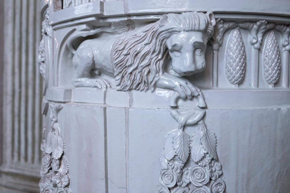 A carved white lion on the stove, seen from the side.