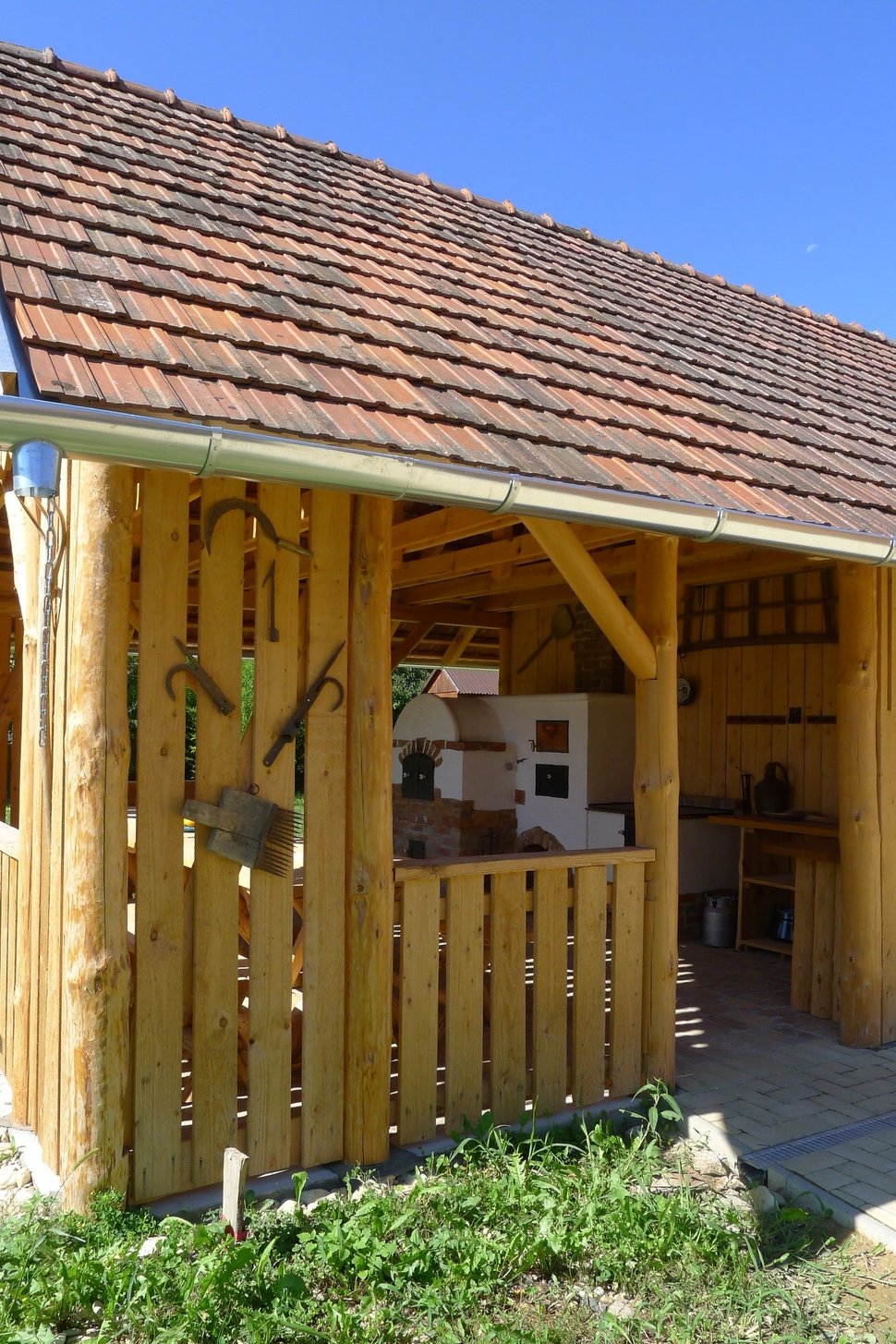 The covered wooden porch of the house, open at the sides.